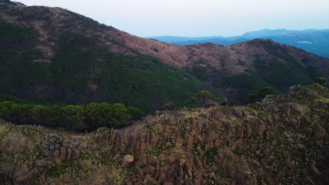 a drone rises up over a rocky ridge in the mountains near estepona, spain