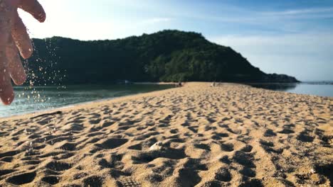 Mano-Goteando-Arena-En-El-Pintoresco-Banco-De-Arena-De-La-Playa-De-Mae-Haad-En-Koh-Phangan,-Tailandia---Cerrar-Cámara-Lenta