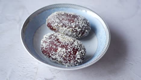 hand picking an indian sweet dish