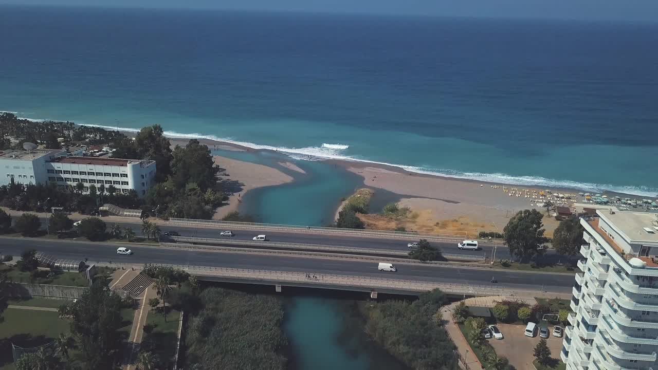 ciudad costera con un río turquesa que desemboca en el mar