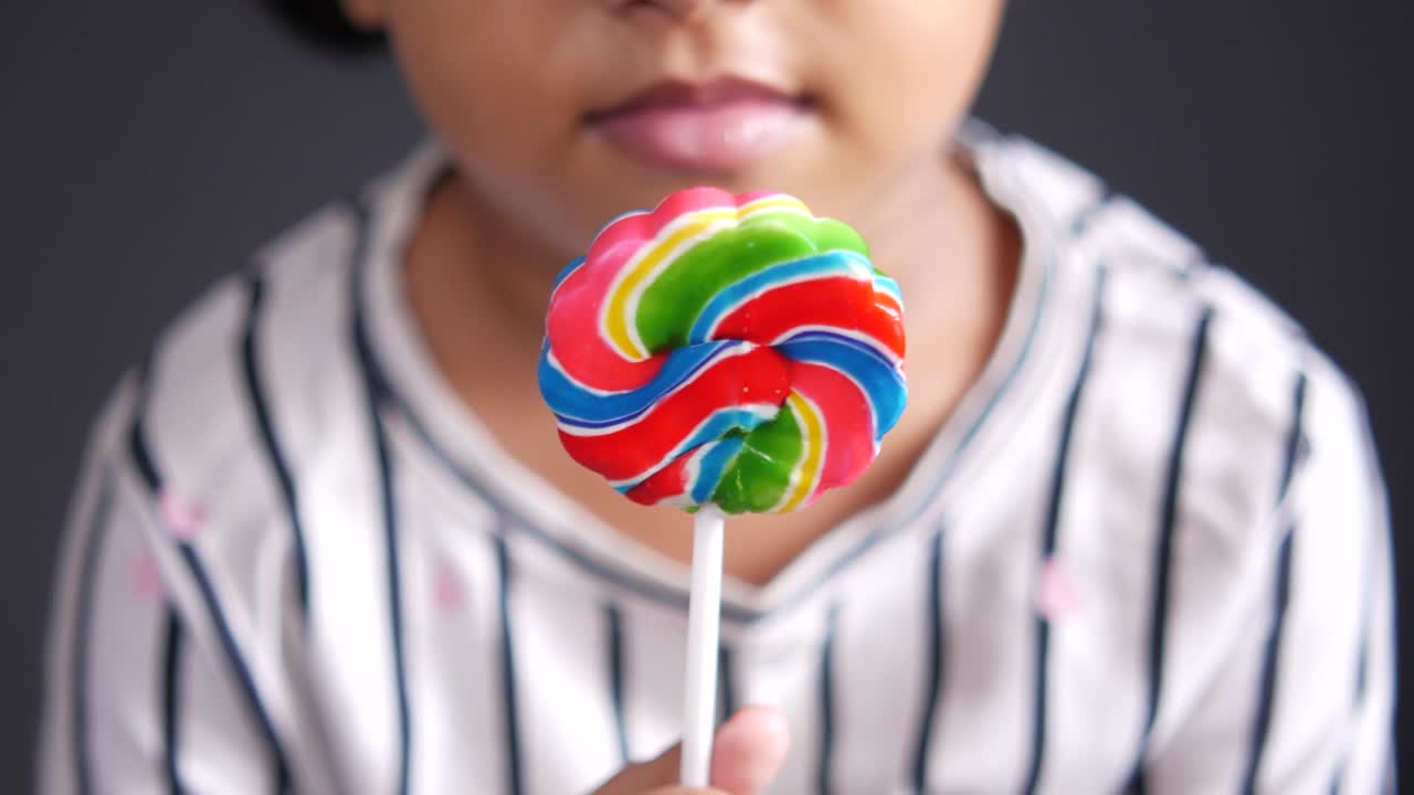 niña con un caramelo de piruleta