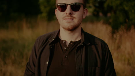 retrato de un hombre de moda con gafas de sol mirando a la cámara al aire libre 2