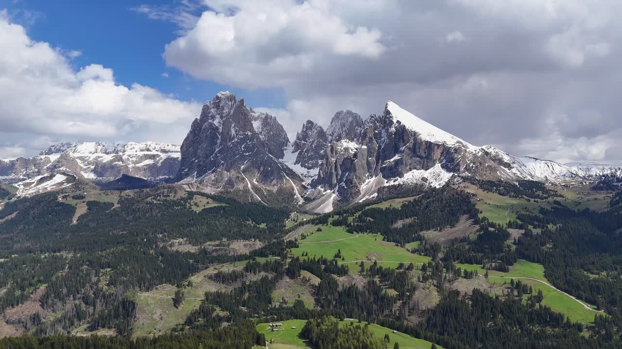 Alpe di Siusi landscape with Sassolungo Group, featuring a drone’s slow circular view of meadows and rugged mountains in the Dolomites