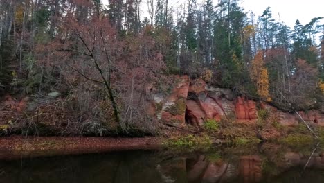 Cueva-De-Los-ángeles,-Un-Acantilado-De-Arenisca-Roja-En-Forma-De-Alas-De-ángel,-En-El-Río-Salaca-En-El-Parque-Natural-Skanaiskalns-En-Mazsalaca,-Letonia,-Tiempo-De-Otoño