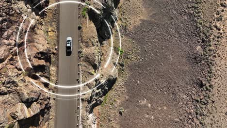 overhead aerial shot of a self driving truck navigating a steep desert cliff roadway