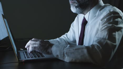 Cropped-shorn-of-businessman-in-headset-using-laptop