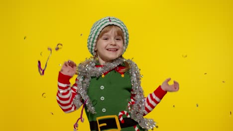 kid child teenager girl in christmas elf santa helper costume having fun rejoices over confetti rain