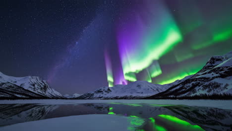 vibrant aurora borealis reflecting over snowy mountains and frozen lake