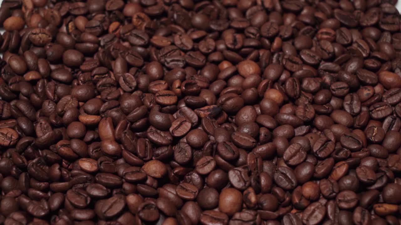 Schwenk nach unten, Haufen Kaffeebohnen isoliert auf weißem Hintergrund, Nahaufnahme