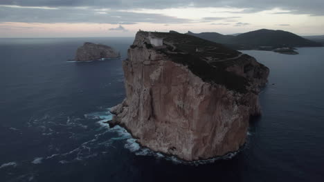 Caccia-cape,-Sardinia:-aerial-view-of-the-lighthouse-of-this-famous-cape-on-the-island-of-Sardinia-and-during-sunset