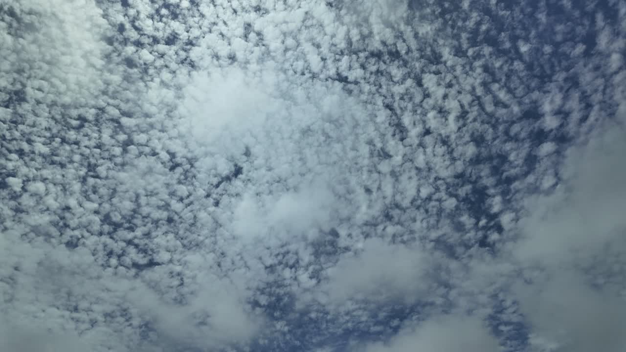glorioso cielo siempre cambiante salpicado de altas nubes cirrus y un avión cruzando la escena de derecha a izquierda subiendo