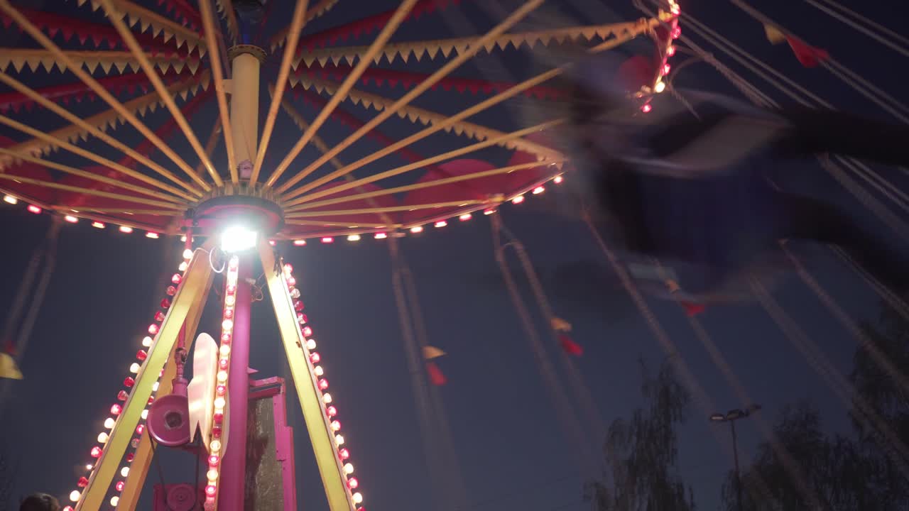 Close up of chain carousel with people