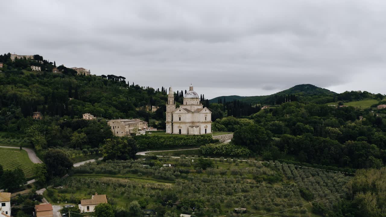 Drone shot of Italy's countryside with a few sandstone buildings throughout the landscape