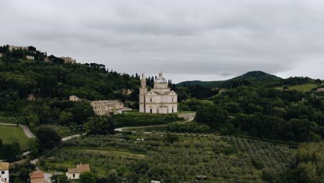 drone shot of italy's countryside with a few sandstone buildings throughout the landscape