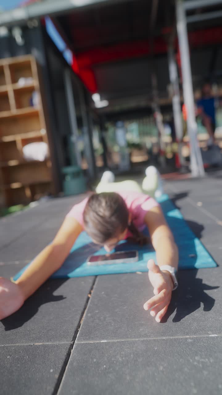 Young woman performing back extension exercise on a yoga mat