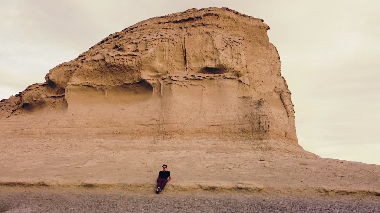 joven viajero recostado descansando junto a un acantilado de arenisca al atardecer - libertad y viaje - tiro de diapositiva aérea