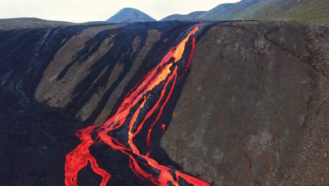 lava fundida caliente que fluye del volcán fagradalsfjall en islandia - toma aérea