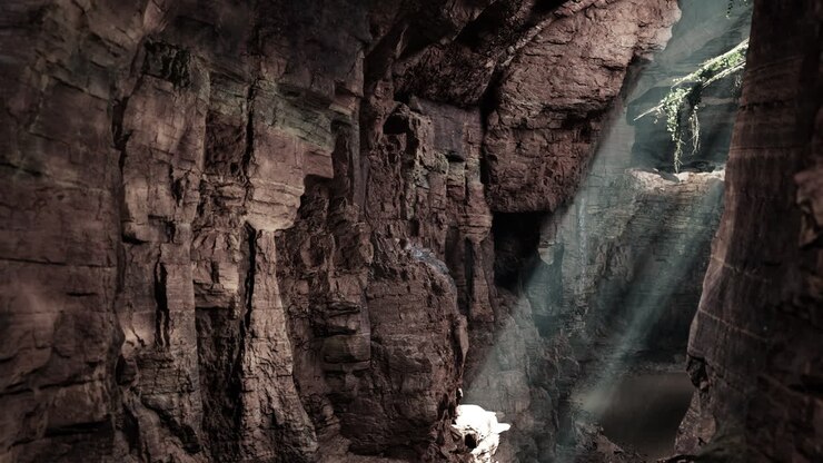 A beam of sunlight shines into a dark cave