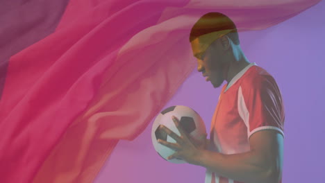 holding soccer ball, man with flowing pink fabric in animation background