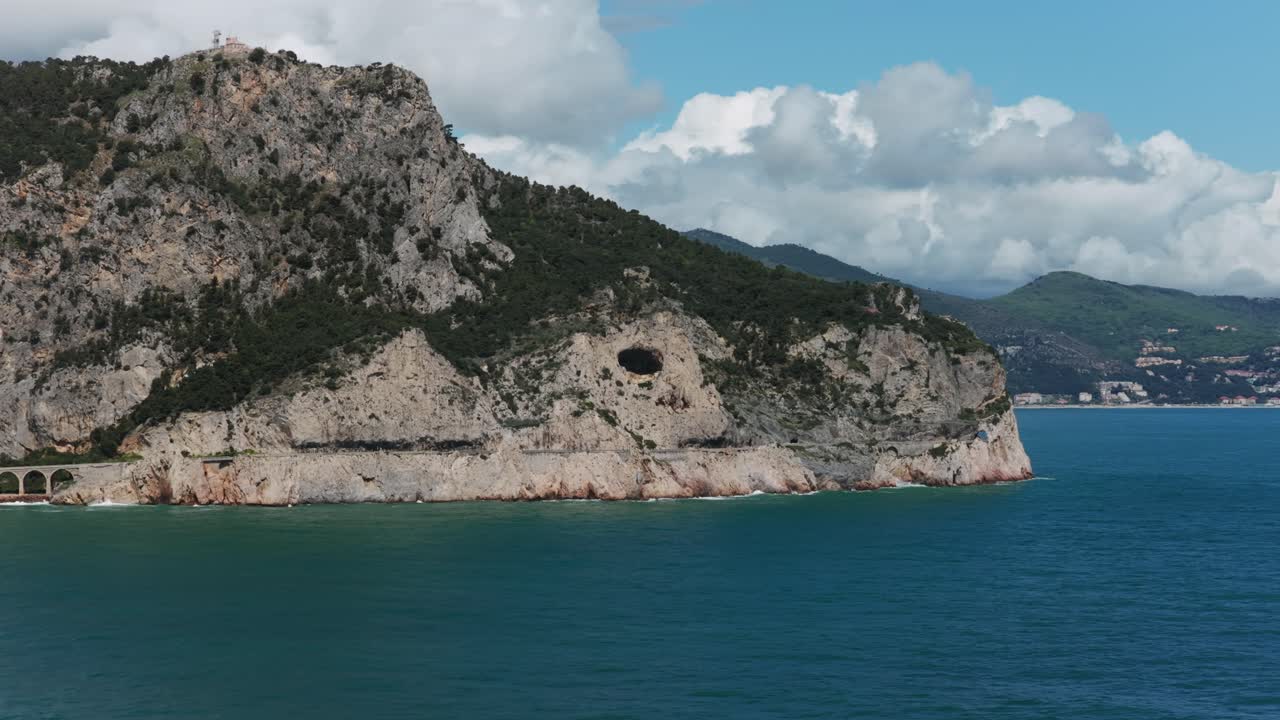 Drone reveals beautiful coastal town of Noli nestled by mountains and turquoise Ligurian Sea. Travel destination, Italian Riviera, Italy