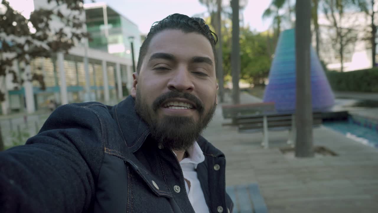 hombre chateando por video y sonriendo a la cámara