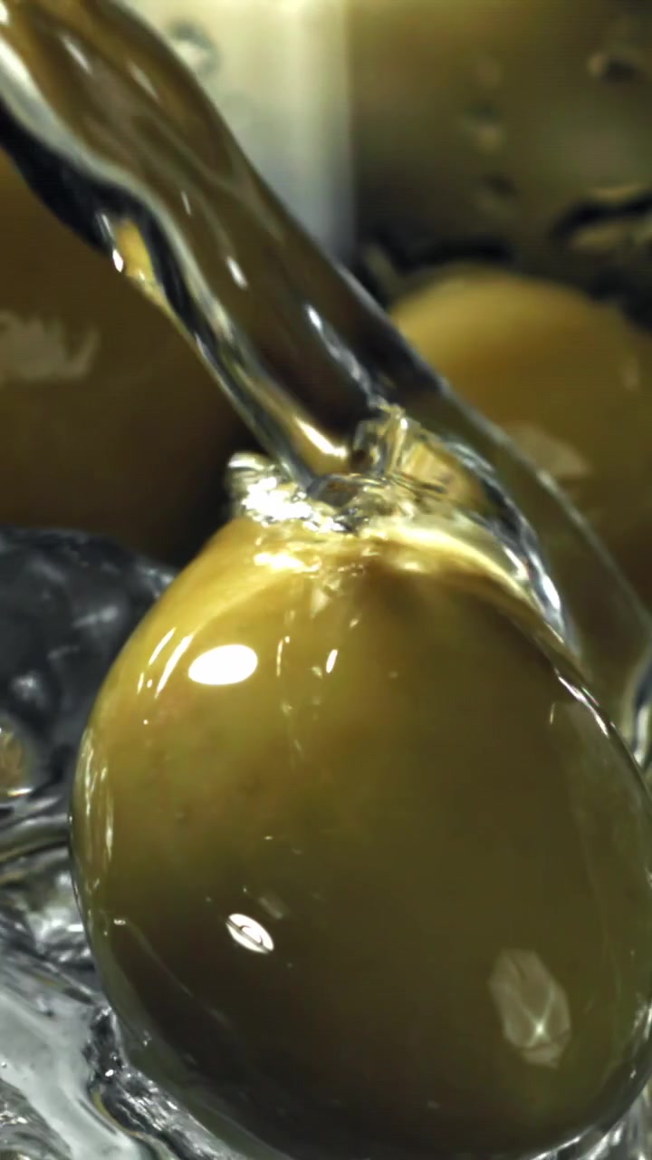Acqua che si versa su olive verdi fresche al rallentatore