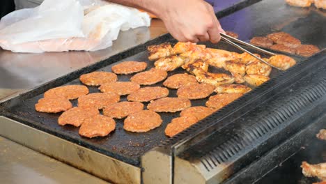 cocinando hamburguesas y pollo en una parrilla
