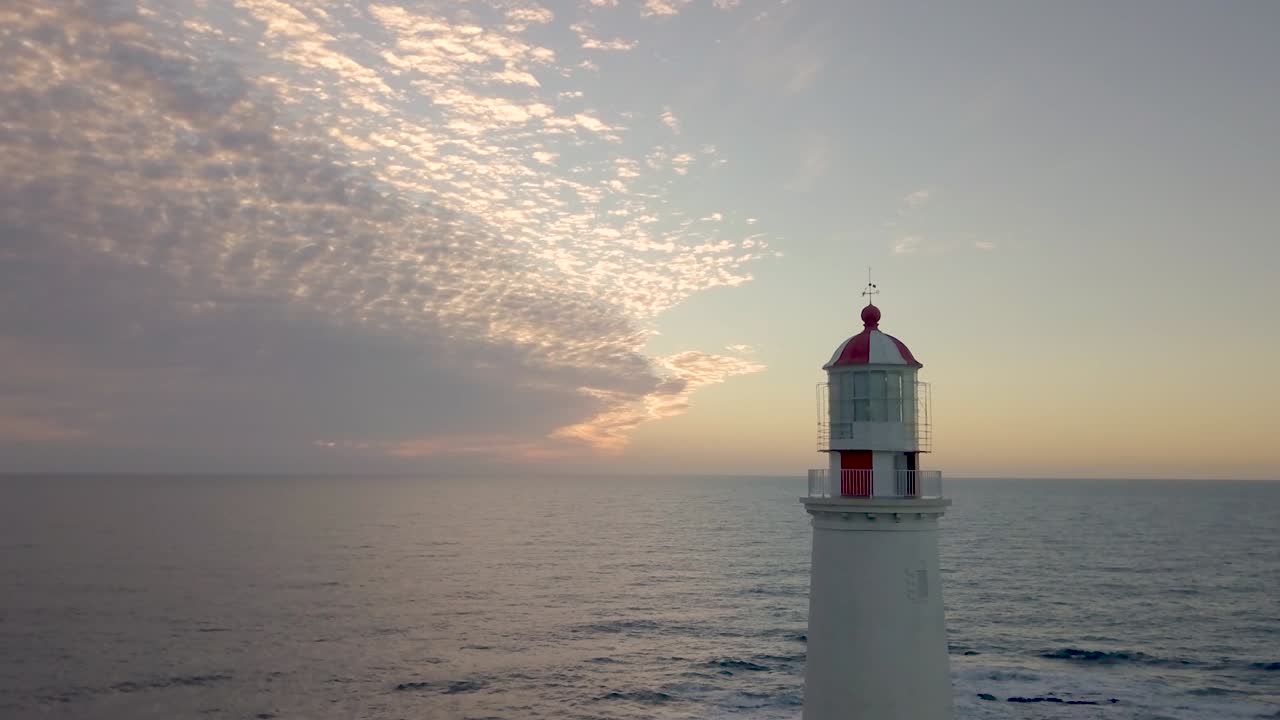 aerial view of the lighthouse with the ocean behind and the sunrise with a calm sea in La paloma, Rocha, Uruguay