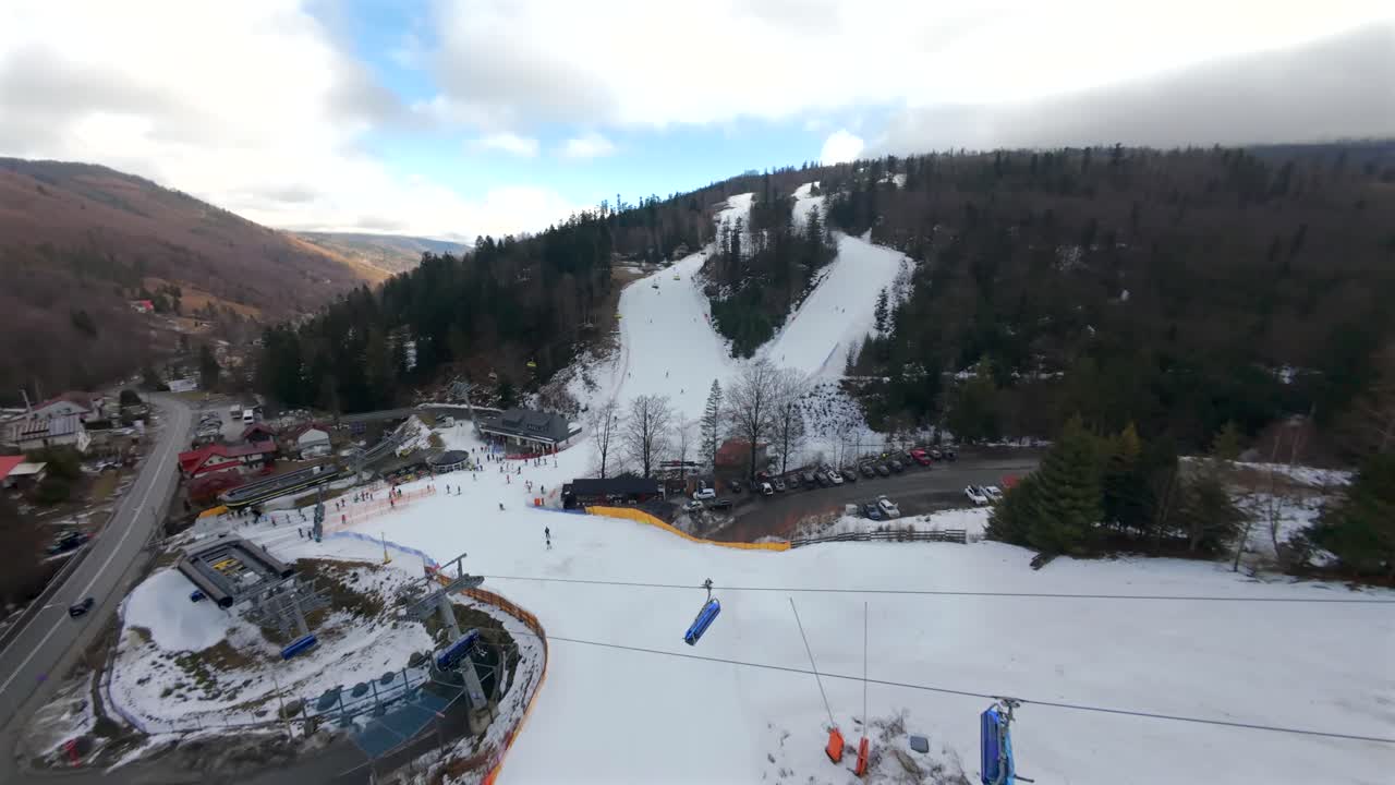 Prospettiva FPV unica sulle piste invernali di Solisko. Sciatori e snowboarder in un paesaggio innevato.