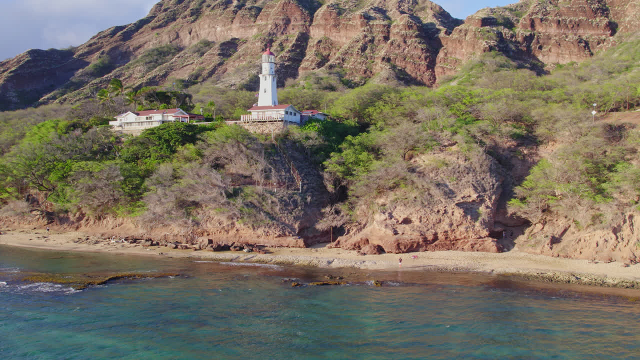 Filmato con drone del faro di Diamond Head a Oahu, Hawaii, con la formazione montuosa vulcanica di Diamond Head dietro di esso sull'isola.