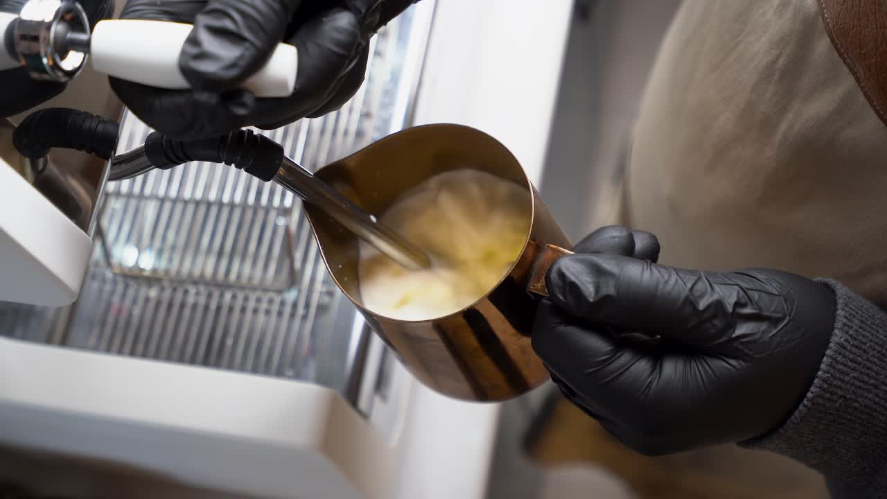 바리스타는 우유를 증기시키고 우유 거품으로 바 ⁇ 니다.