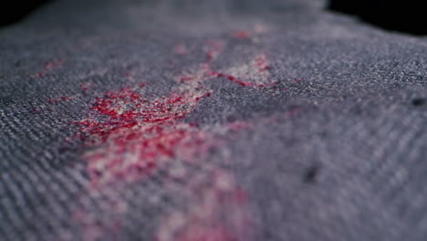closeup view of reddish stains on dark denim fabric, beautifully showcasing the intricate texture and color contrast