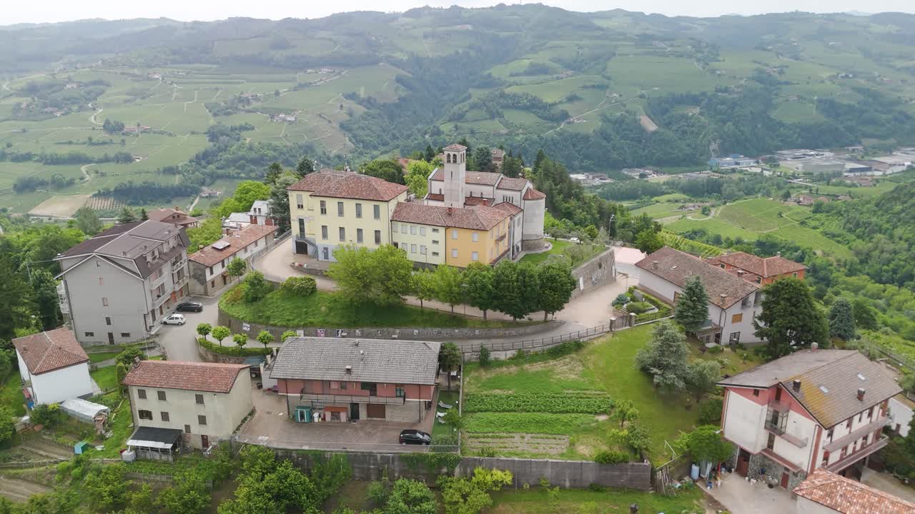 vista aérea de un pueblo ubicado en las colinas italianas con viñedos