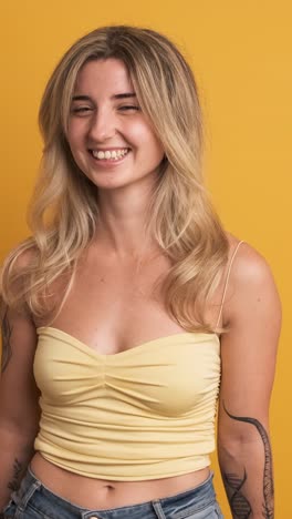chilling young woman standing against yellow background