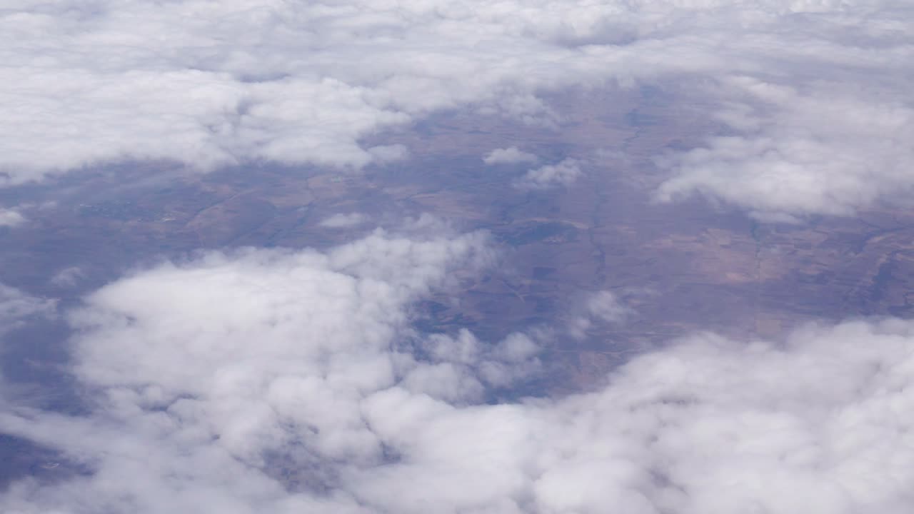 Veduta di nuvole bianche che coprono parzialmente il paesaggio sottostante - vista dall'alto