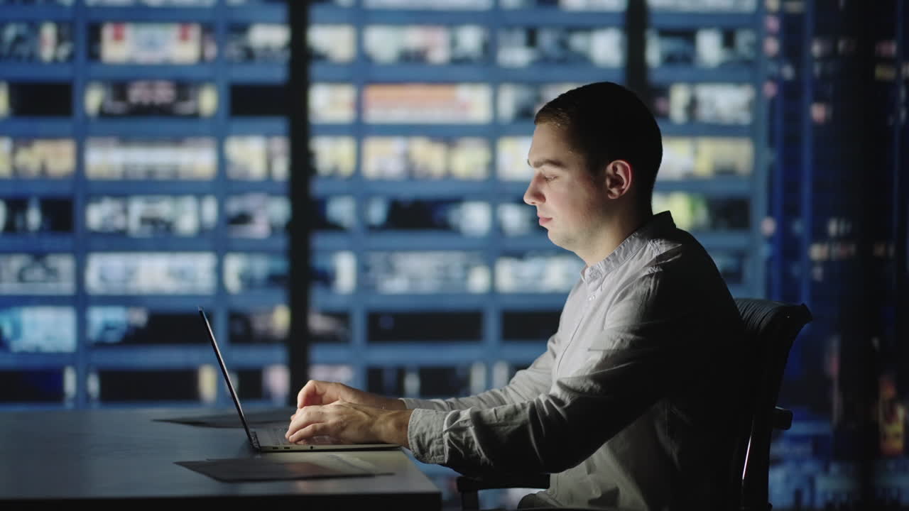 hombre de negocios regresando a la oficina abriendo la tapa de la computadora portátil y continuando en el trabajo nocturno. hombre caucásico guapo contra la escena de la ciudad nocturna en el fondo.