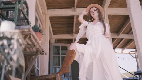 bohemian woman in a white dress on a porch