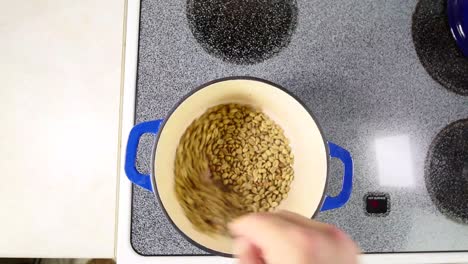 asar granos de café verde en casa en una olla de hierro fundido