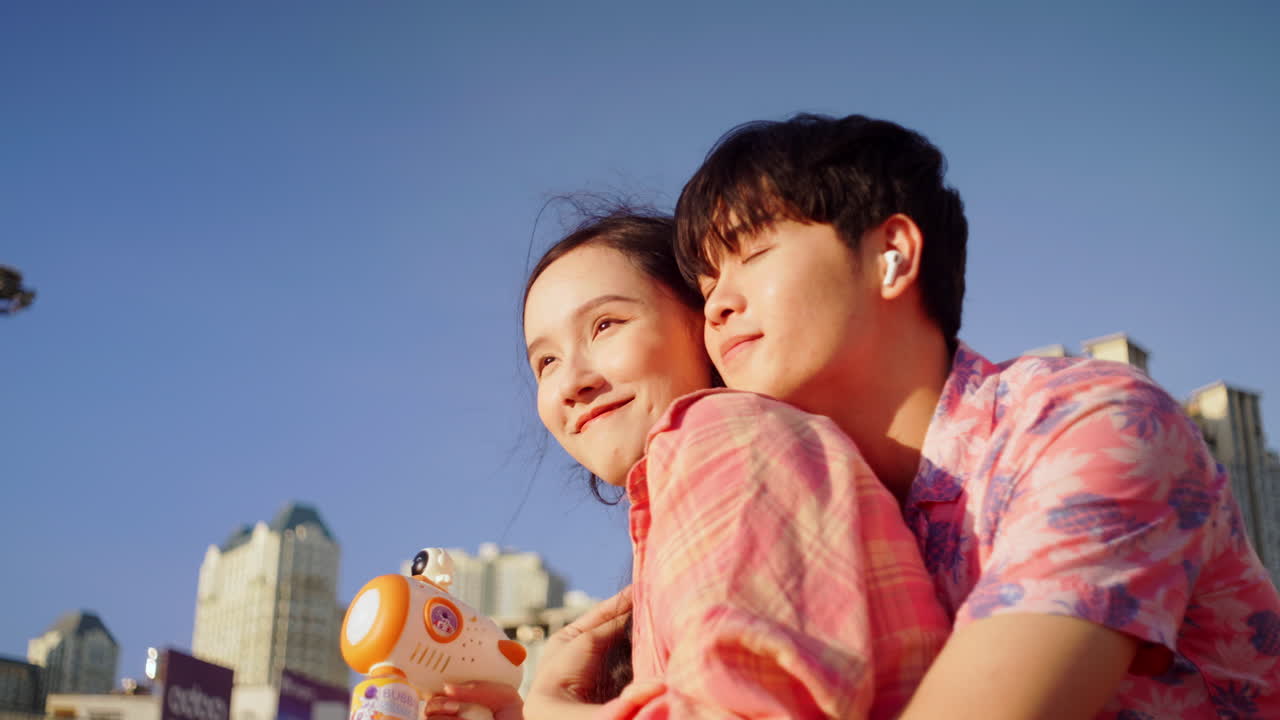 아시아의 젊은 연인 부부는 은 여름날에 큰 도시에서 더 단단하게 여행합니다.