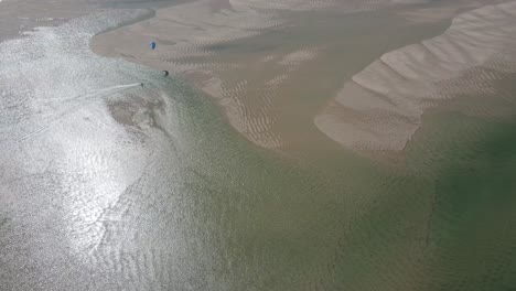 An athlete doing windsurfing on a river estuary in Portugal. Shot in slow motion 100fps