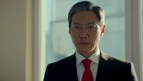 portrait of a businessman in a suit with a red tie