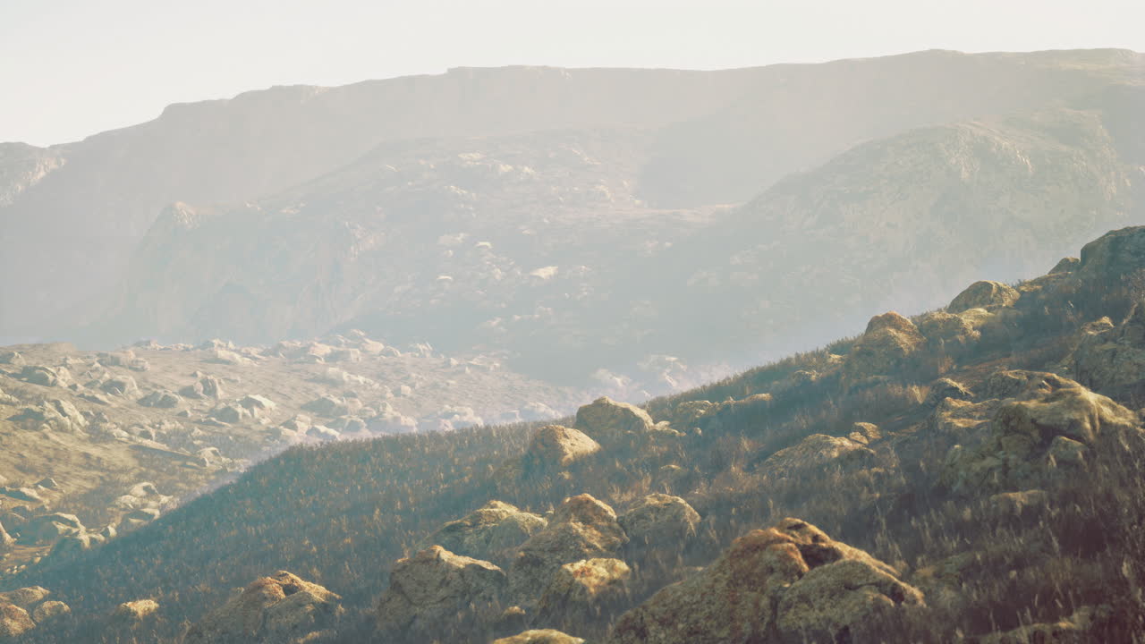 Scenic view of rocky landscape with rolling hills at sunset hour