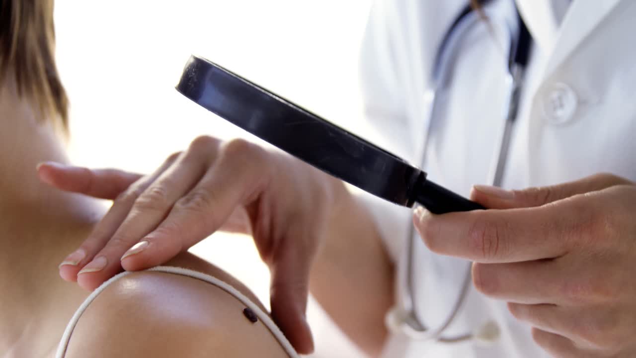 primer plano de una terapeuta examinando un punto de belleza de su paciente