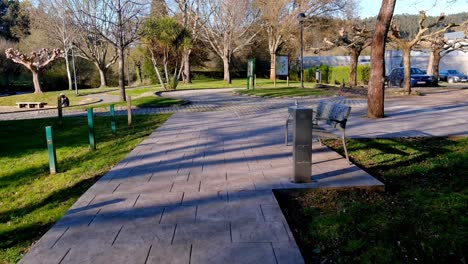 punto de vista a lo largo de las aceras vacías en el parque recreativo más allá del banco