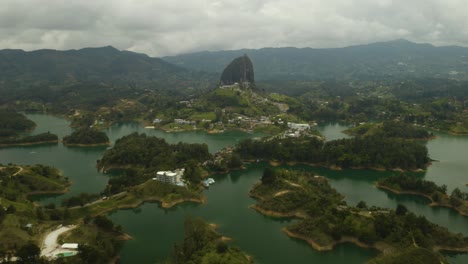 drone volando sobre el lago guatape hacia la roca guatape