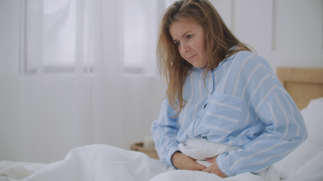 Stomachache. The redhead girl has awful stomachache at her home. Abdominal pain. Her menstrual cramps are too painful to go to work