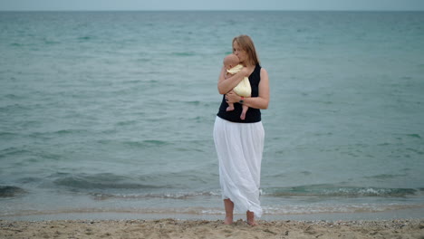 mother cuddling baby scene at the beach against the sea