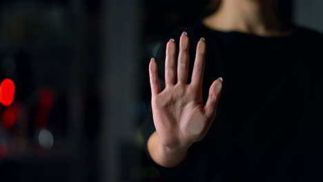 primer plano de una mano femenina tocando una pared de vidrio en el interior. una chica deja una huella de mano.