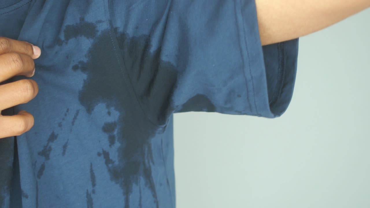 Person with sweat stains on their t-shirt