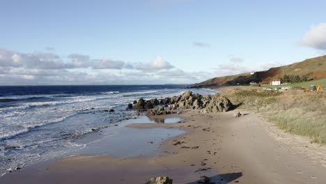 beautiful aerial shot of an empty beach on the coast of scotland in summer sun